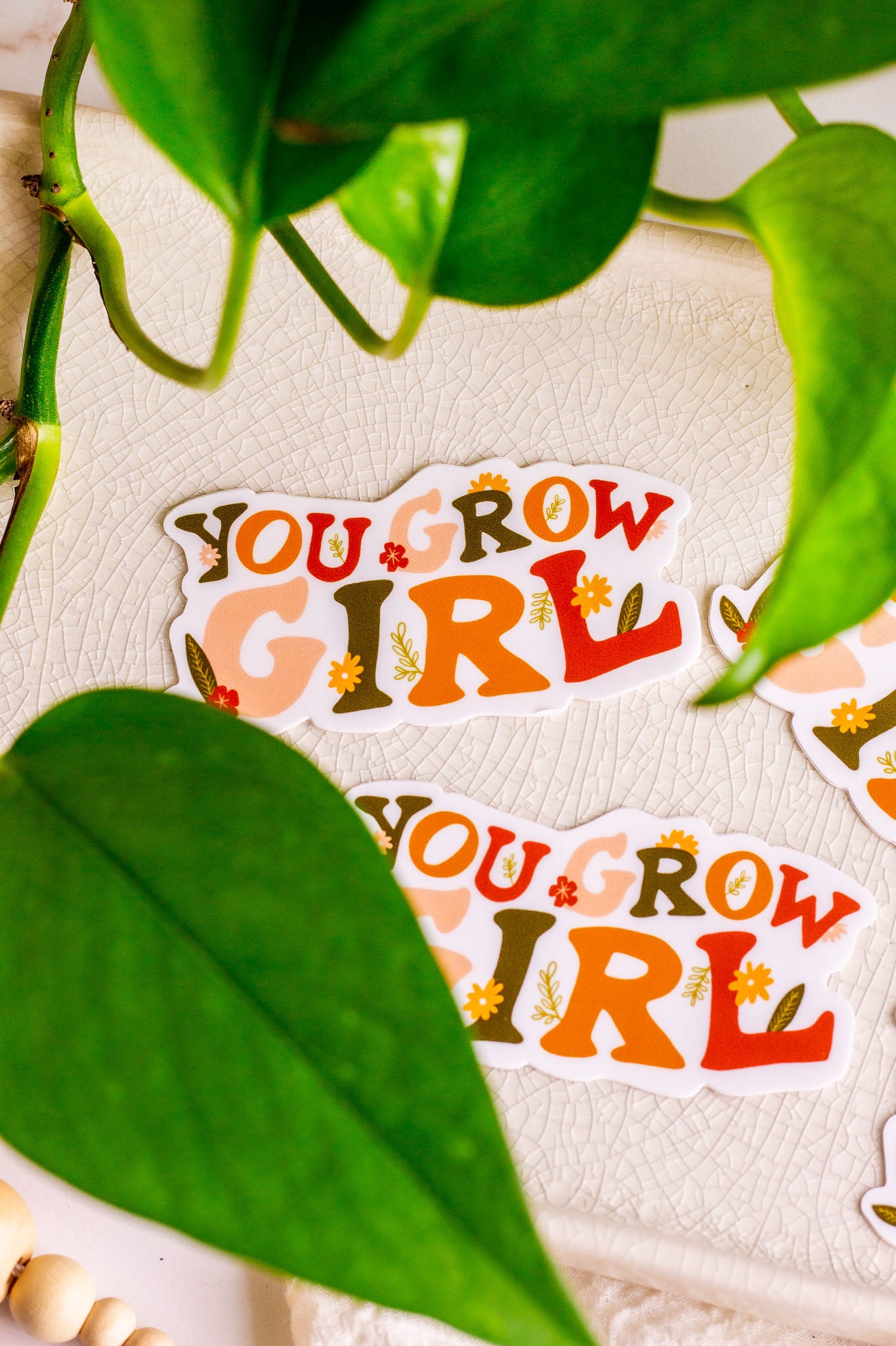 You Grow Girl Vinyl Sticker laying on a decorative tray with greenery surrounding it