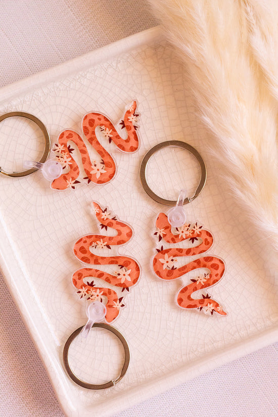 Floral Snake Keychains laying on a decorative tray