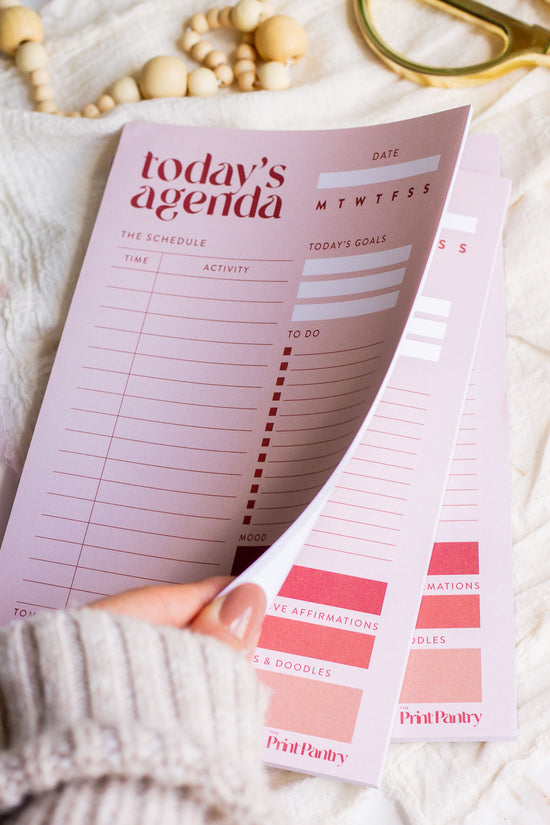 Woman flipping through a Daily Agenda Notepad
