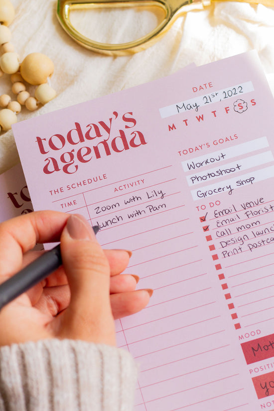 Woman writing in a Daily Agenda Notepad