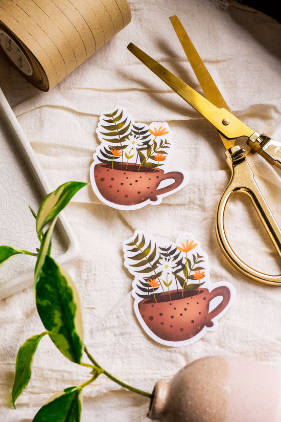 Floral Tea Cup Stickers laying on decorative fabric with journaling supplies laying next to them