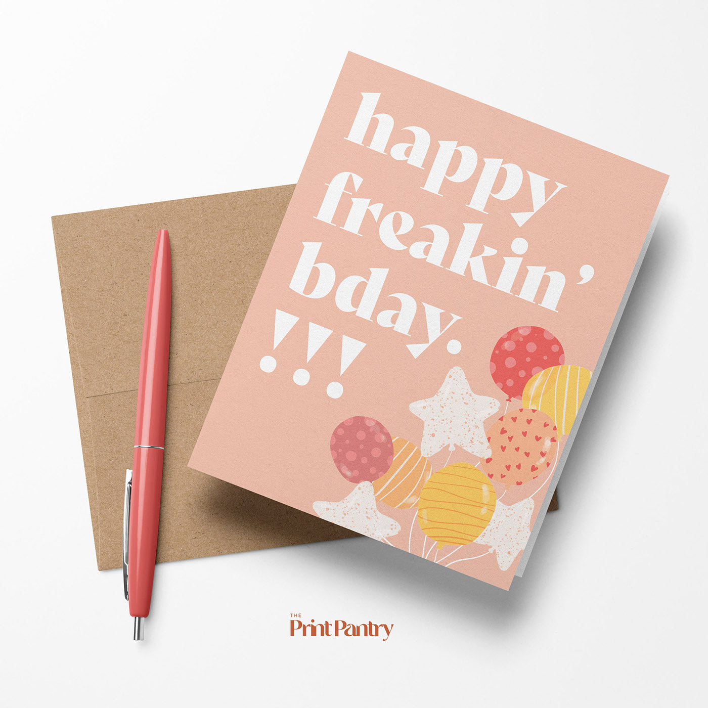 Happy Freakin' Birthday Greeting Card laying on a Kraft paper envelope with a pen