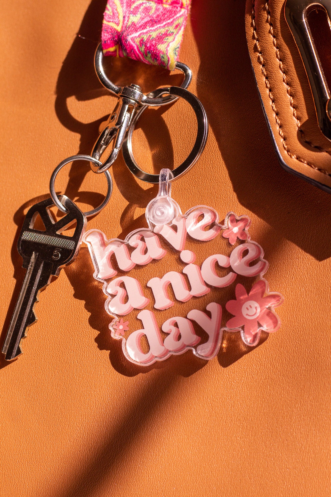 Have a Nice Day Keychain sitting on purse