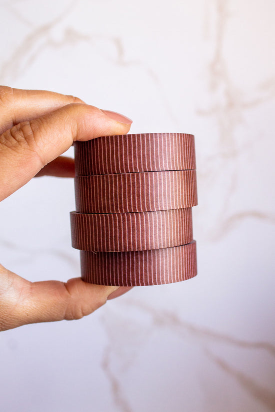 Woman holding a stack of Quirky Lines Washi Tape