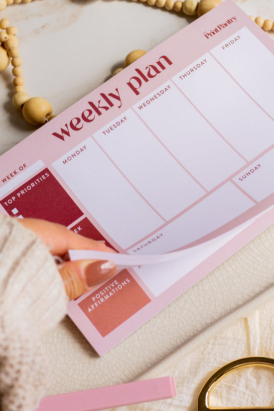 Woman flipping through a Weekly Plan Notepad