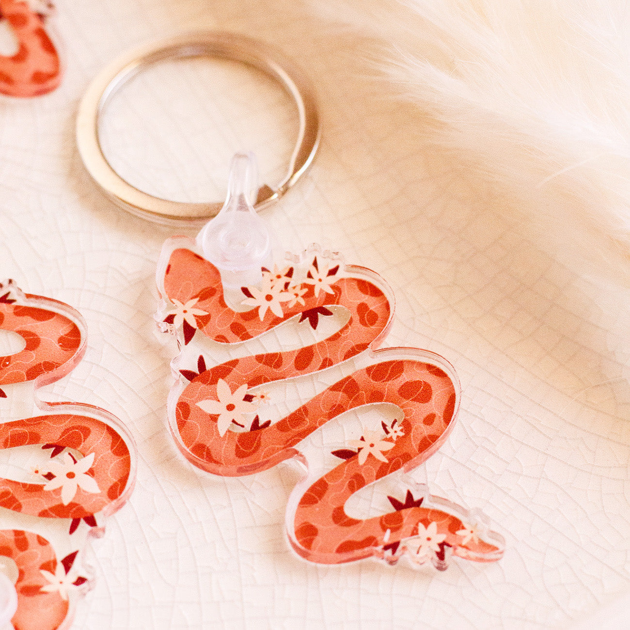 Floral Snake Keychain laying on decorative tray