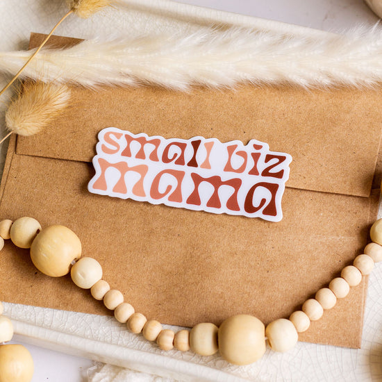 Load image into Gallery viewer, Small Biz Mana Vinyl Sticker laying on a Kraft paper envelope

