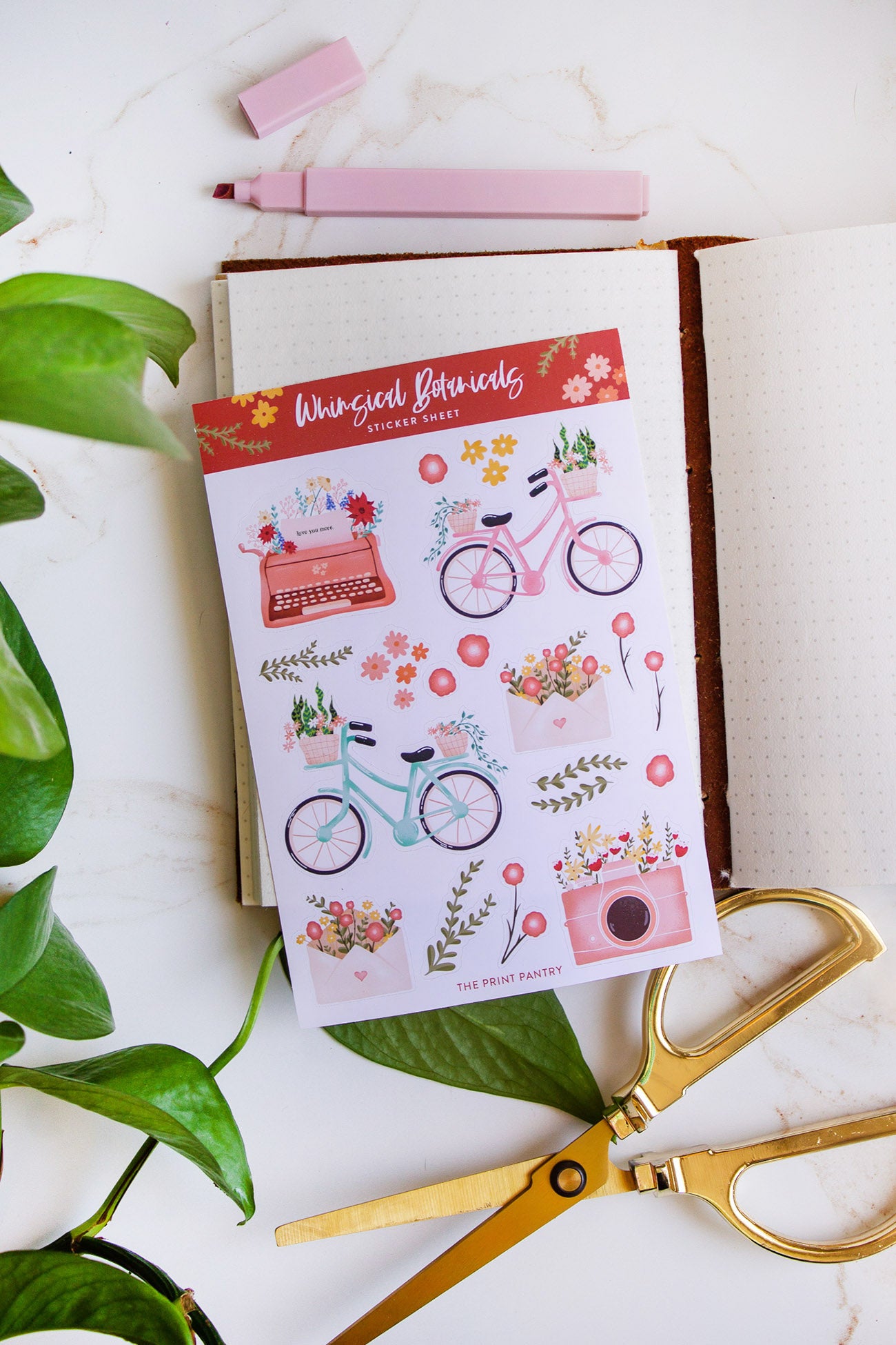Whimsical Botanical Sticker Sheet laying on a notebook